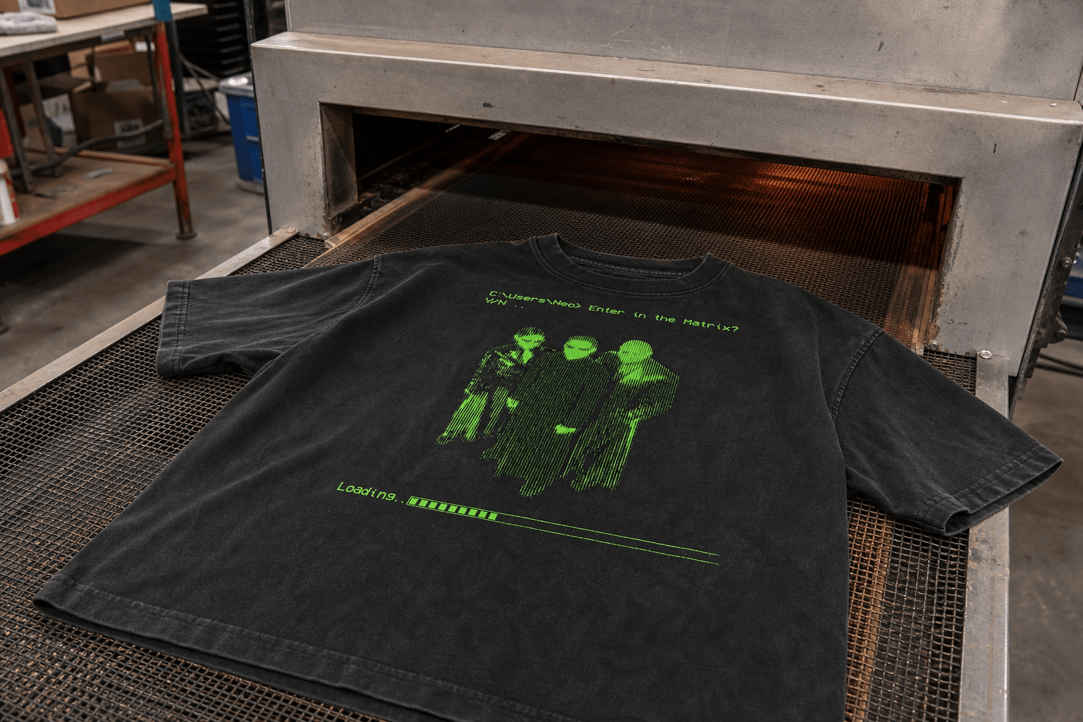 Washed black graphic T-shirt moving through a conveyor dryer