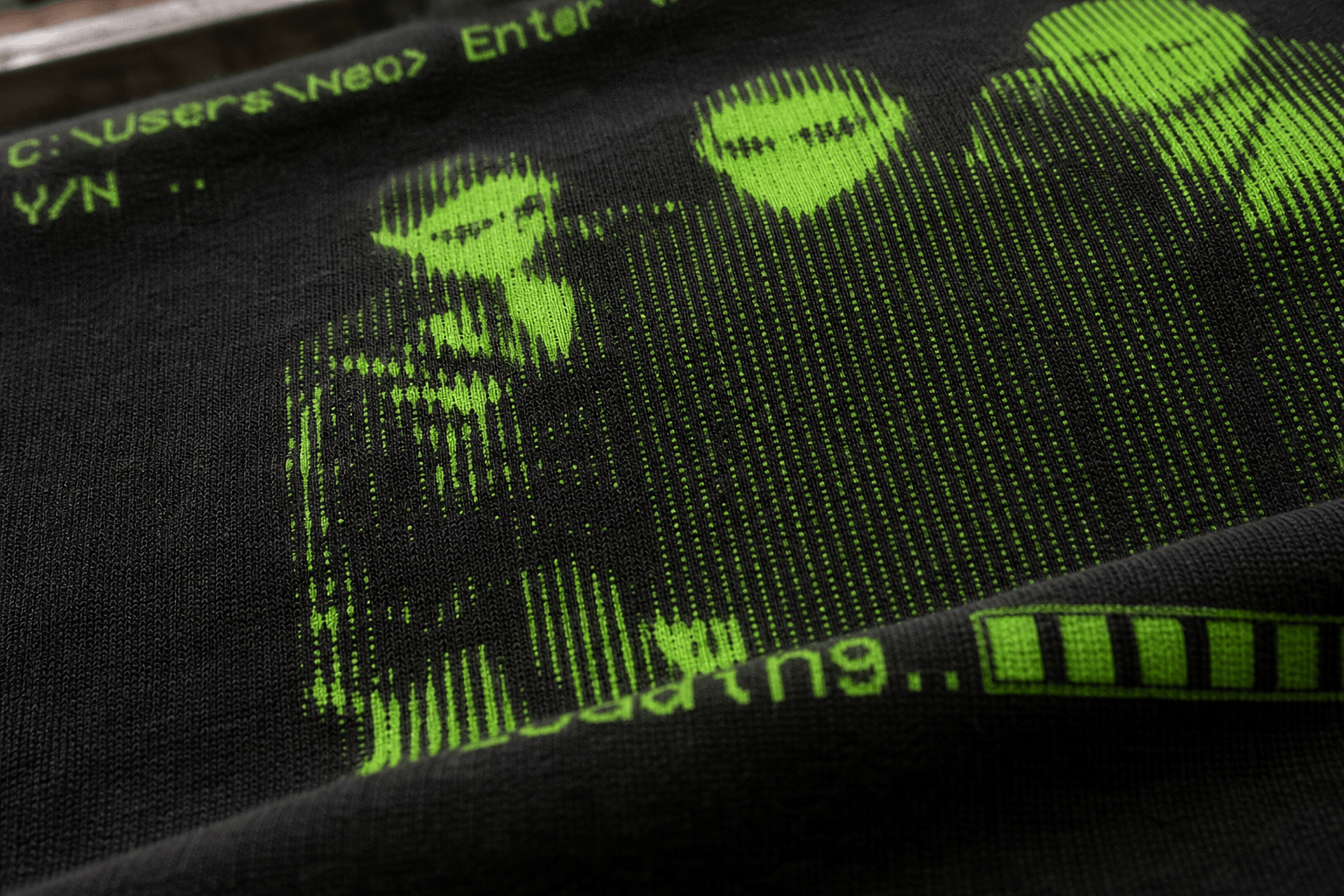 Macro view of green screen-print ink following black cotton texture