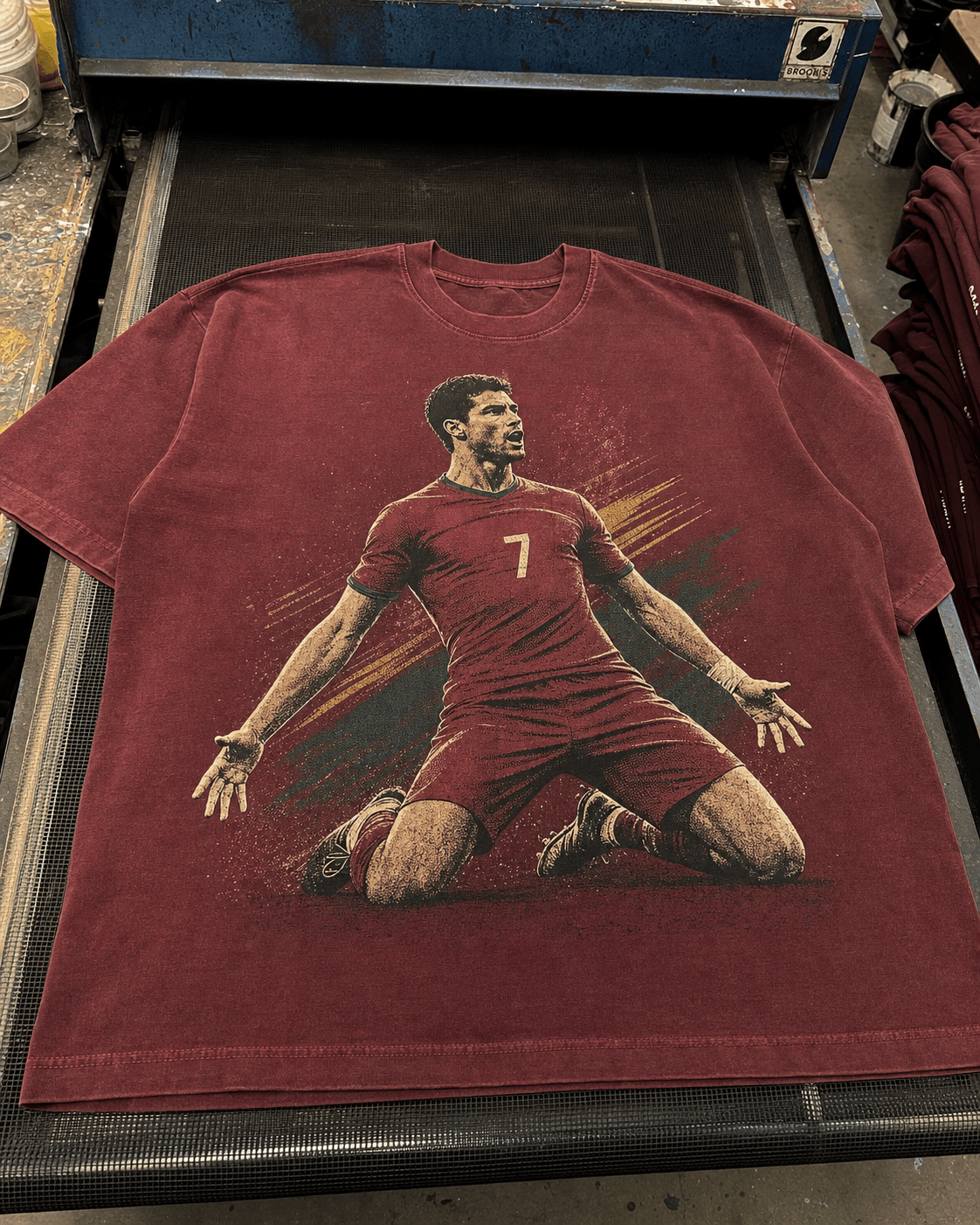 Washed red football graphic T-shirt on a conveyor dryer
